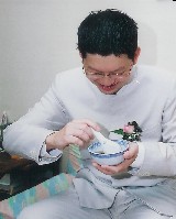 groom in chinese style jacket drinking sweet soup